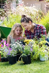 Mother and daughter gardening together in garden