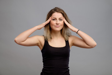 Woman having headache isolated on gray