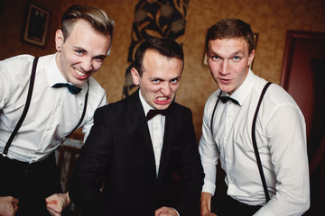 Joyful groom and his funny friends