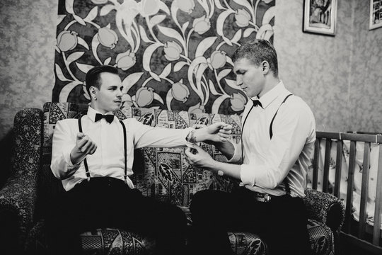 Groomsman is helping to dress up to the groom