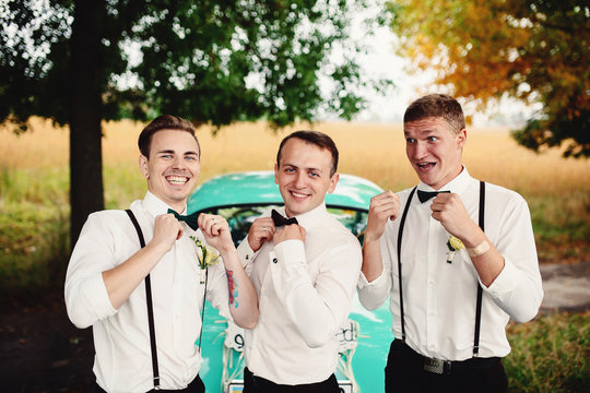 Groom and his handsome groomsmen next to the car
