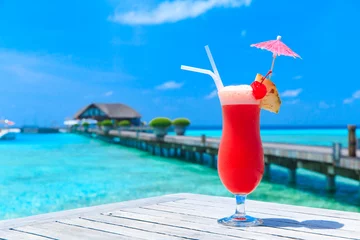 Fototapeten Cocktail mit unscharfem Strand im Hintergrund © Pakhnyushchyy
