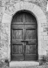 The entrance wooden door in an old Italian house. (black and white).