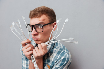 Young hipster in glasses with cables