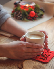 Morning cup of coffee in hands and candle