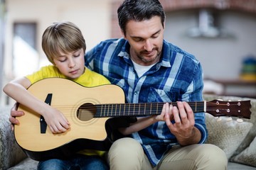 Father and son playing a guitar