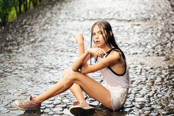 Pretty girl under summer rain