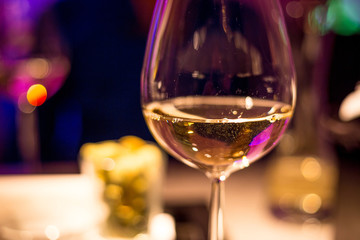 Glass of Wine in the Bar of Luxury Hotel with Amazing Purple Blurred Background
