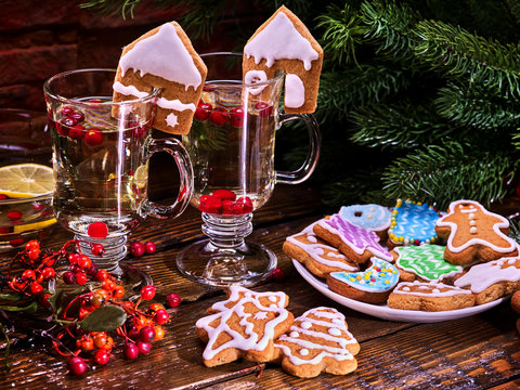 Christmas cookies on plate with fir branches. Christmas still life with pair mug hot drink on wooden table in restaurant.