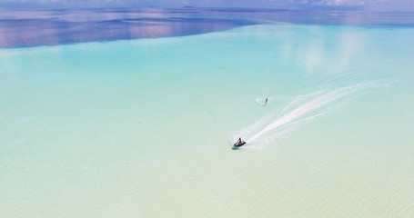 Maldives island Indian Ocean jet ski wakeboarding aerial top view. 