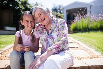 Fototapeta premium Grandmother and granddaughter sitting in the garden