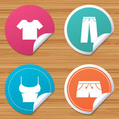 Round stickers or website banners. Clothes icons. T-shirt and pants with shorts signs. Swimming trunks symbol. Circle badges with bended corner. Vector