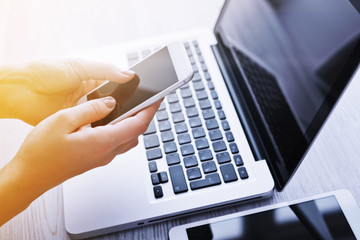 Woman's hands using mobile phone at the office