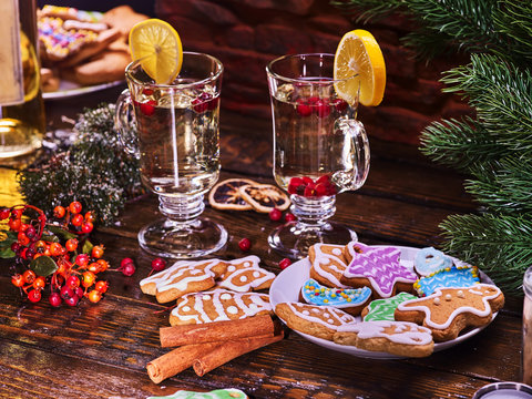 Christmas cookies on plate with fir branches. Christmas still life with pair mug decoration lemon slice hot drink on wooden table. Table in cafe.