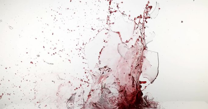 Glass of Red Wine Breaking and Splashing against White Background, Slow motion 4K