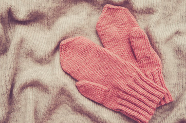 Pink mittens handmade on a soft warm background (vintage)