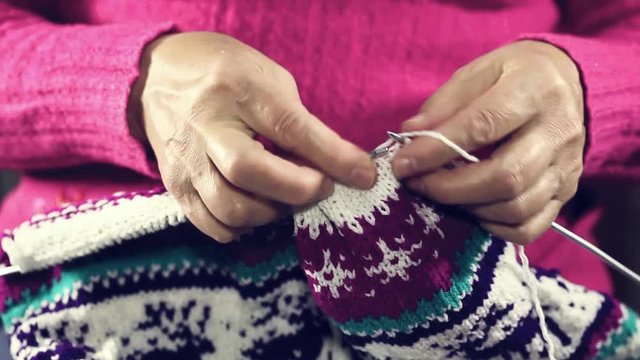 woman hands knitting colorful wool yarn.