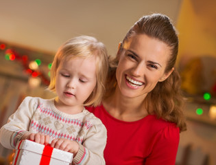 Portrait of happy mother and baby opening christmas present box