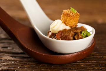 Shrimp tortelline, morning gravy, radish and black salt  in a spoon. Taste gastronomy fingerfood