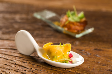 Shrimp tortelline, morning gravy, radish and black salt  in a spoon. Taste gastronomy fingerfood