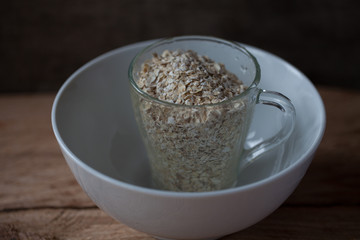 Oat flakes in a glass mug on a wooden background selective focus