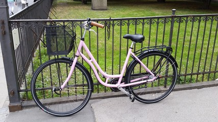 Fototapeta na wymiar Pink Bike on Black Fence