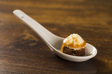 Brownie with cupuacu cream and salted caramel in a spoon. Taste gastronomy finger food