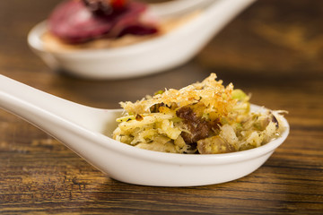 Shredded cod with scrambled eggs, banana puree and crispy potato in a spoon. Taste gastronomy finger food