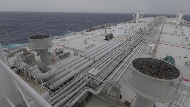 Very large tanker at sea, deck, fresh gale, cloudy.
