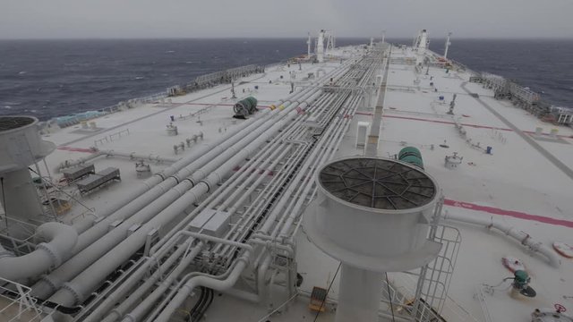 Very large tanker at sea, deck, fresh gale, cloudy.