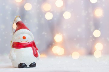 Christmas and new year background - snowman figurine against christmas lights, with copy space
