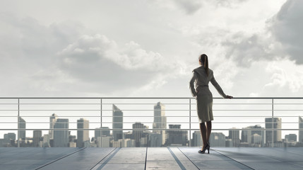 Obraz premium Businesswoman on building roof . Mixed media