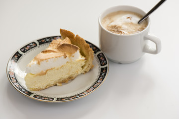 piece of cake on a plate and a cup of coffee