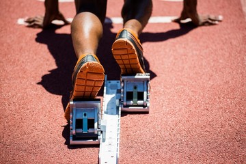 Feet of an athlete on a starting block about to run