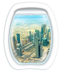 Fototapeta na wymiar Plane window on skyscrapers of Dubai downtown skyline on Sheikh Zayed Road, United Arab Emirates, from a plane through the porthole. Copy space.