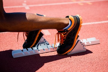 Feet of an athlete on a starting block about to run