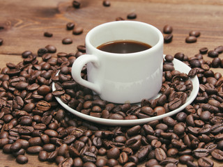 Black coffee in white mug and grains