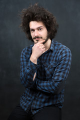 Fototapeta na wymiar Portrait of a fashionable young man on dark background, chalkboa
