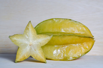 Star apple fruit with half cross section isolated on wooden boar