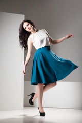 Fototapeta premium Happy beautiful woman in dark blue skirt and white top walking joyfully smiling