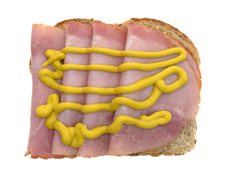 Applewood smoked ham with mustard on bread top view isolated on a white background.