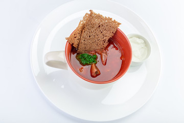 Hot borsch in a white bowl