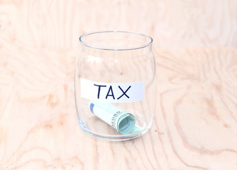 Money jar with money on wood table , Saving for Tax Concept. Time to pay