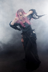 Obraz premium Witch creates magic. Attractive woman with red hair in witches costume