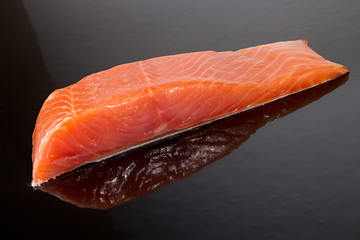 Salmon fillet on black background.