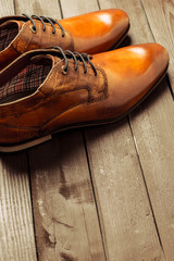 Fashion concept with male shoes on wooden background