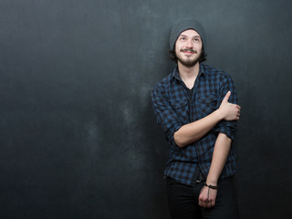 Portrait of a fashionable young man with funny hair on dark back