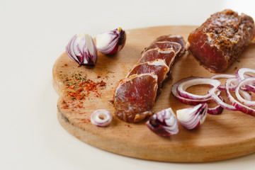 Salted meat with spices on a wooden board
