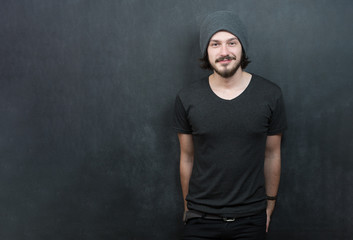 Portrait of a fashionable young man with funny hair on dark back