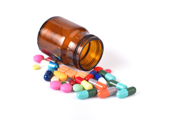 Recipient of medicine and many pills isolated on white backgroun